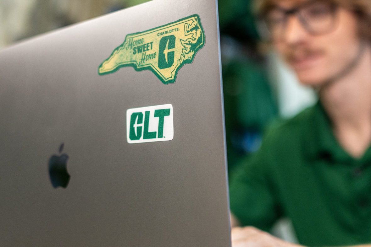 close up of computer with Charlotte logo stickers on it.