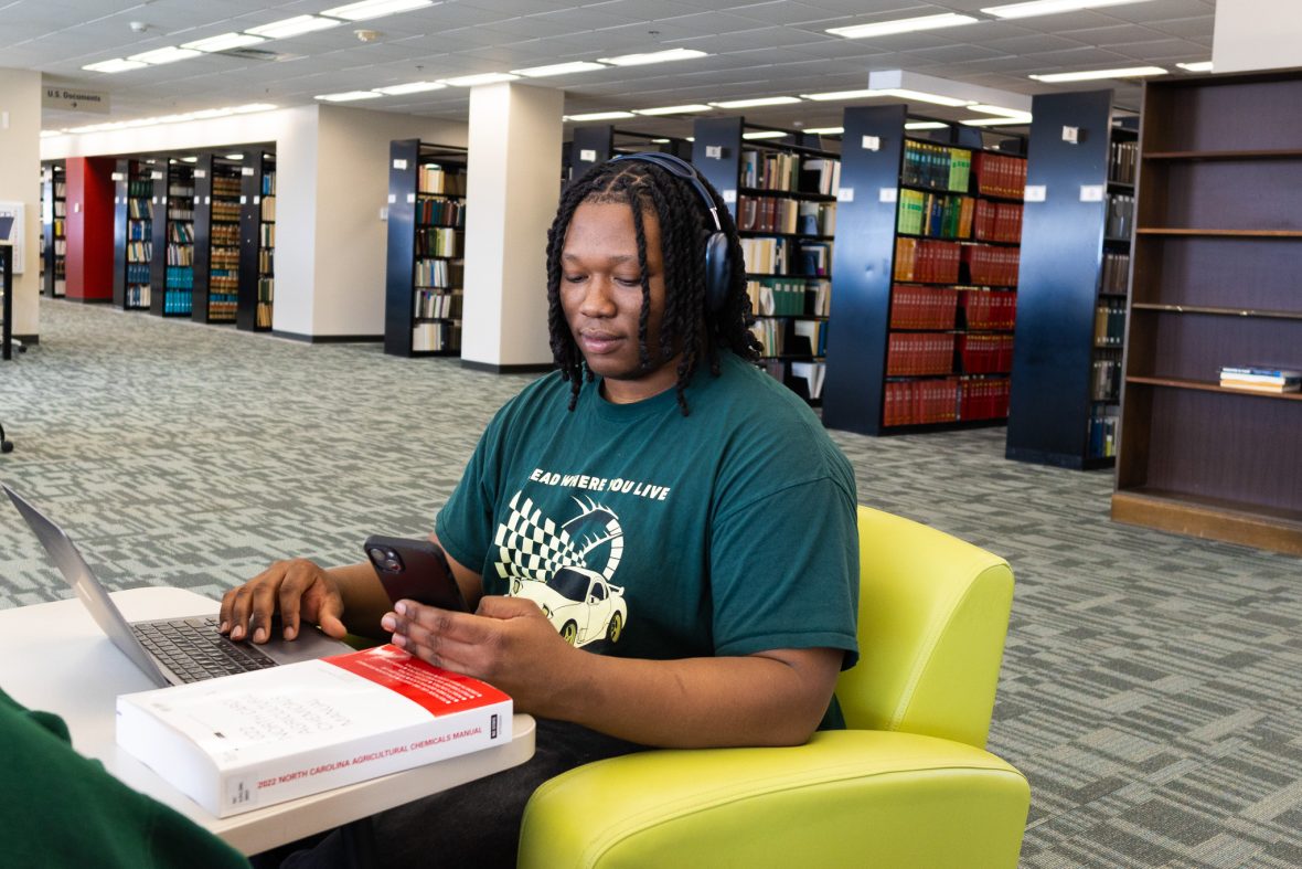 Student on phone in the bookstore social hub.