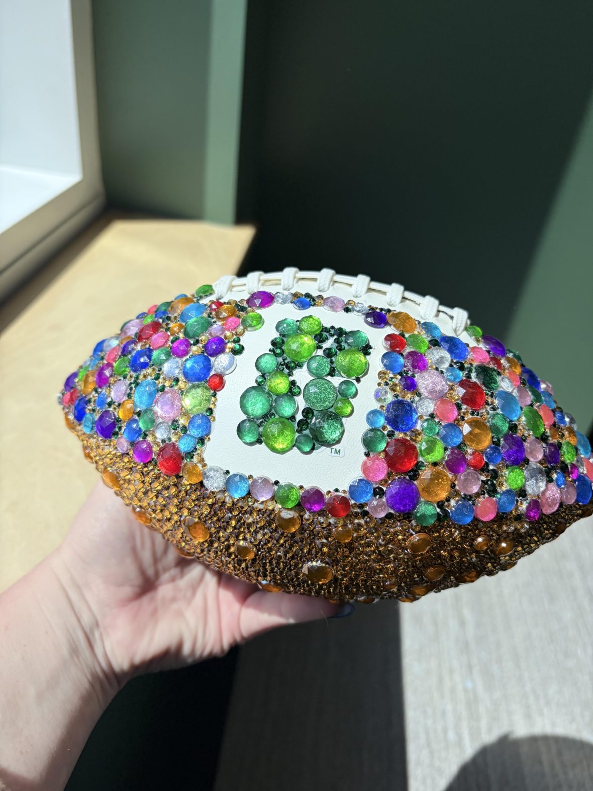 Charlotte-branded football covered in colorful gems and sequins