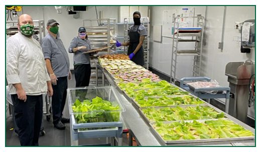 Photo of long table filled with colorful food being prepped for quarantine meals
