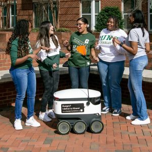 Students gather around Starship robots