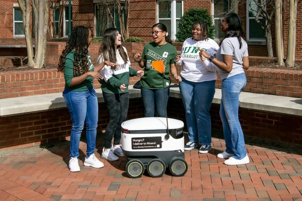 Students gather around Starship robots