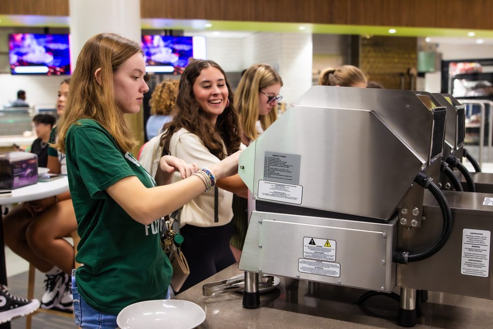 Students serve themselves ice cream at the dessert station