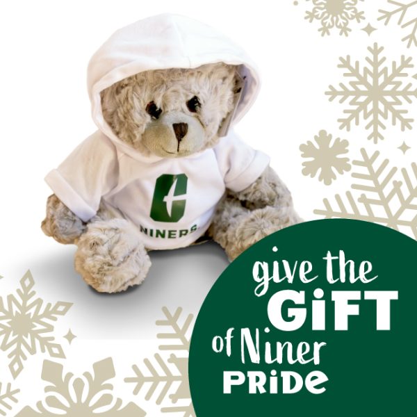 stuffed bear with Charlotte sweater sits in snowflake border behind text "give the gift of Niner Pride"