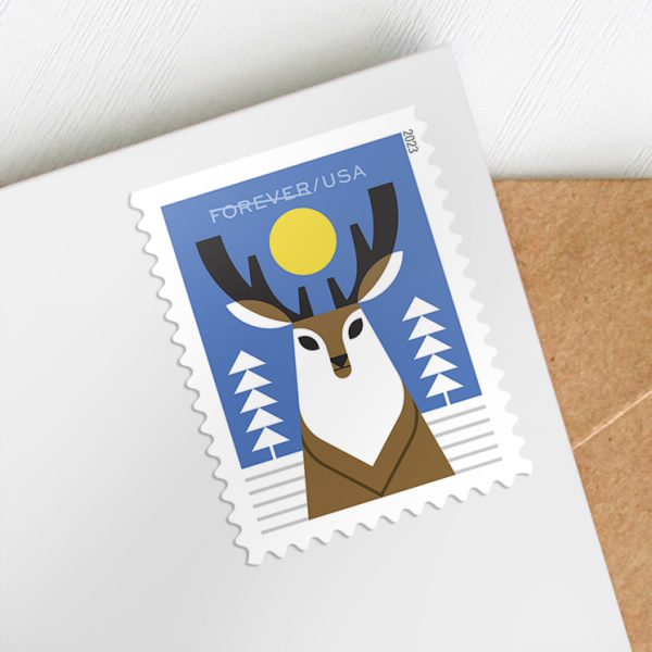 stamp with a stylistically illustrated reindeer standing in a snowy landscape