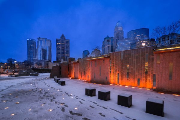 Snow covered streets in the evening with Charlotte, NC city buildings in the background